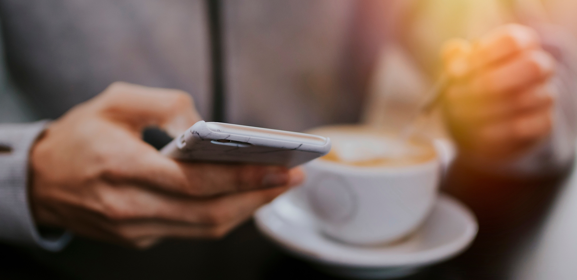 person with coffee and a cell phone